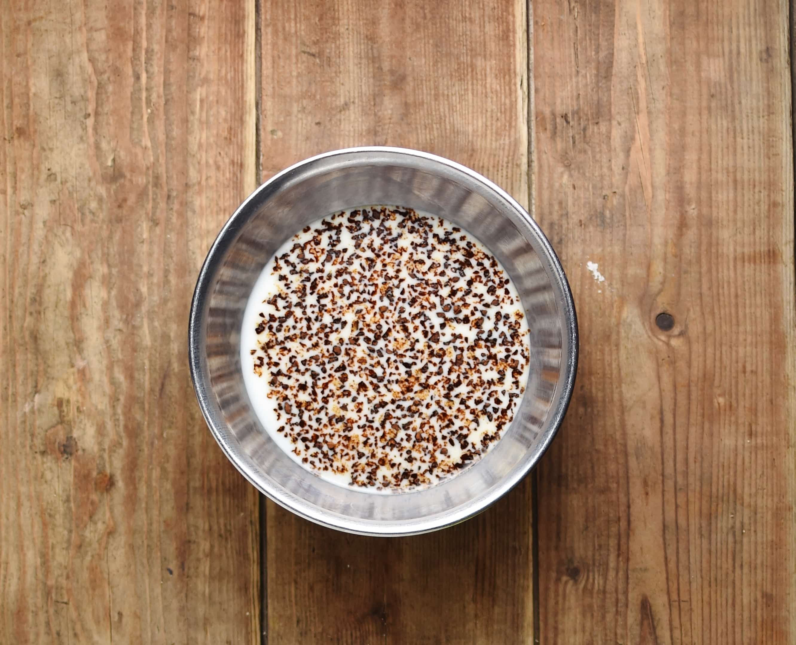 Coffee granules with milk in metal bowl.