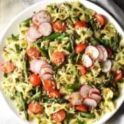 Top down view of asparagus pasta salad on large white plate.