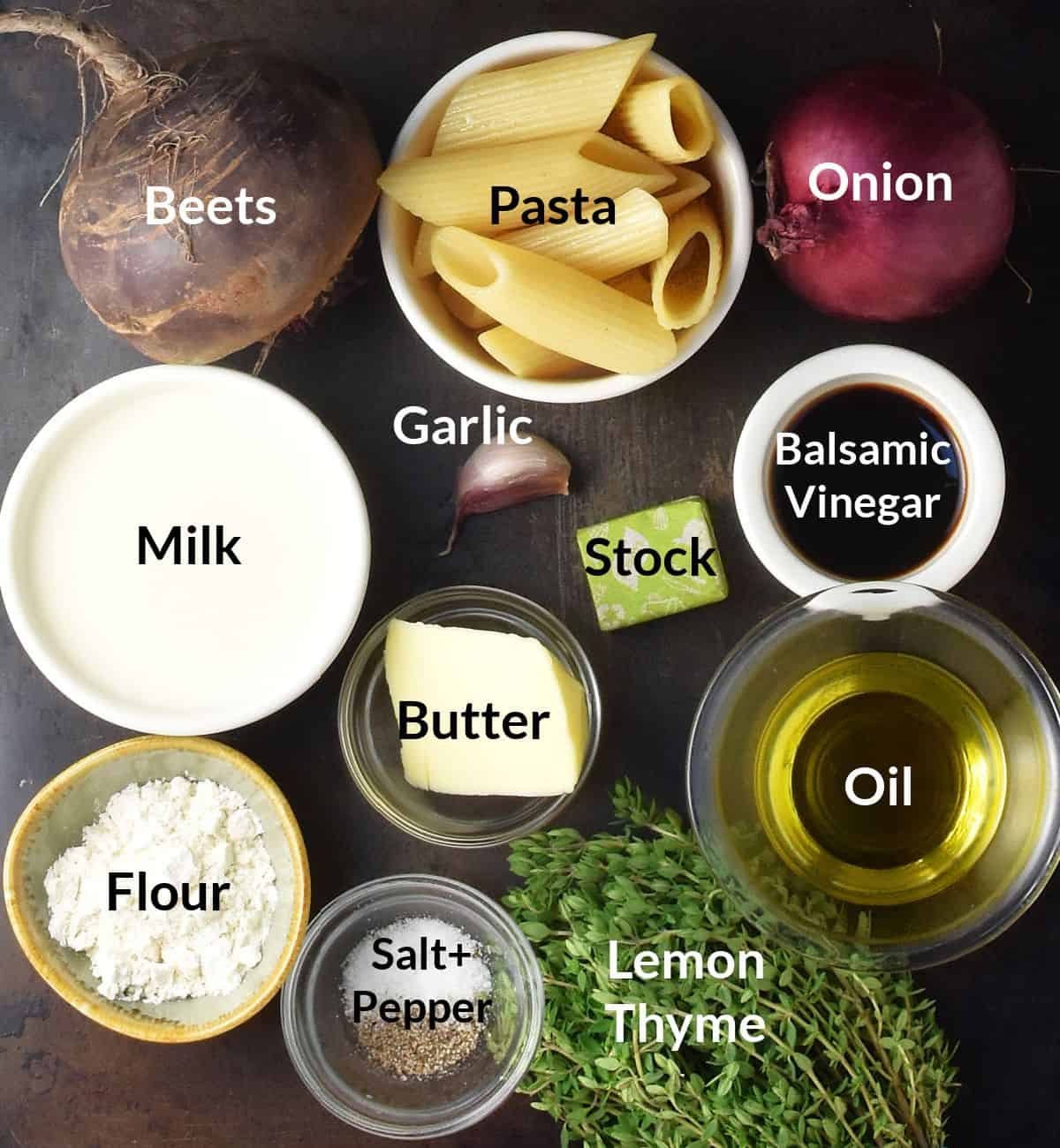 Ingredients for making beet pasta sauce in individual dishes on top of dark surface.