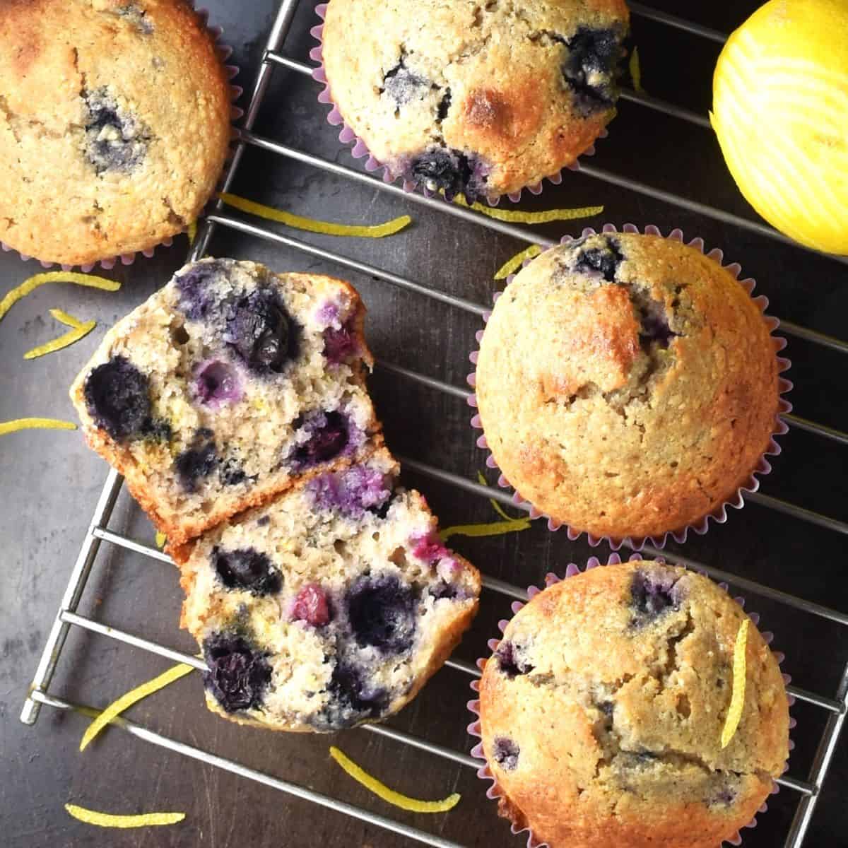 Top down view of blueberry buckwheat muffins with lemon on rack.