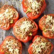 Top down view of cauliflower rice stuffed peppers with meat on parchment.