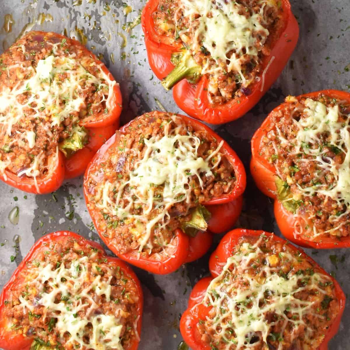 Top down view of cauliflower rice stuffed peppers with meat on parchment.