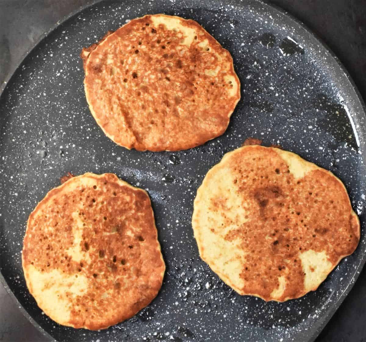 3 pancakes on top of pan.
