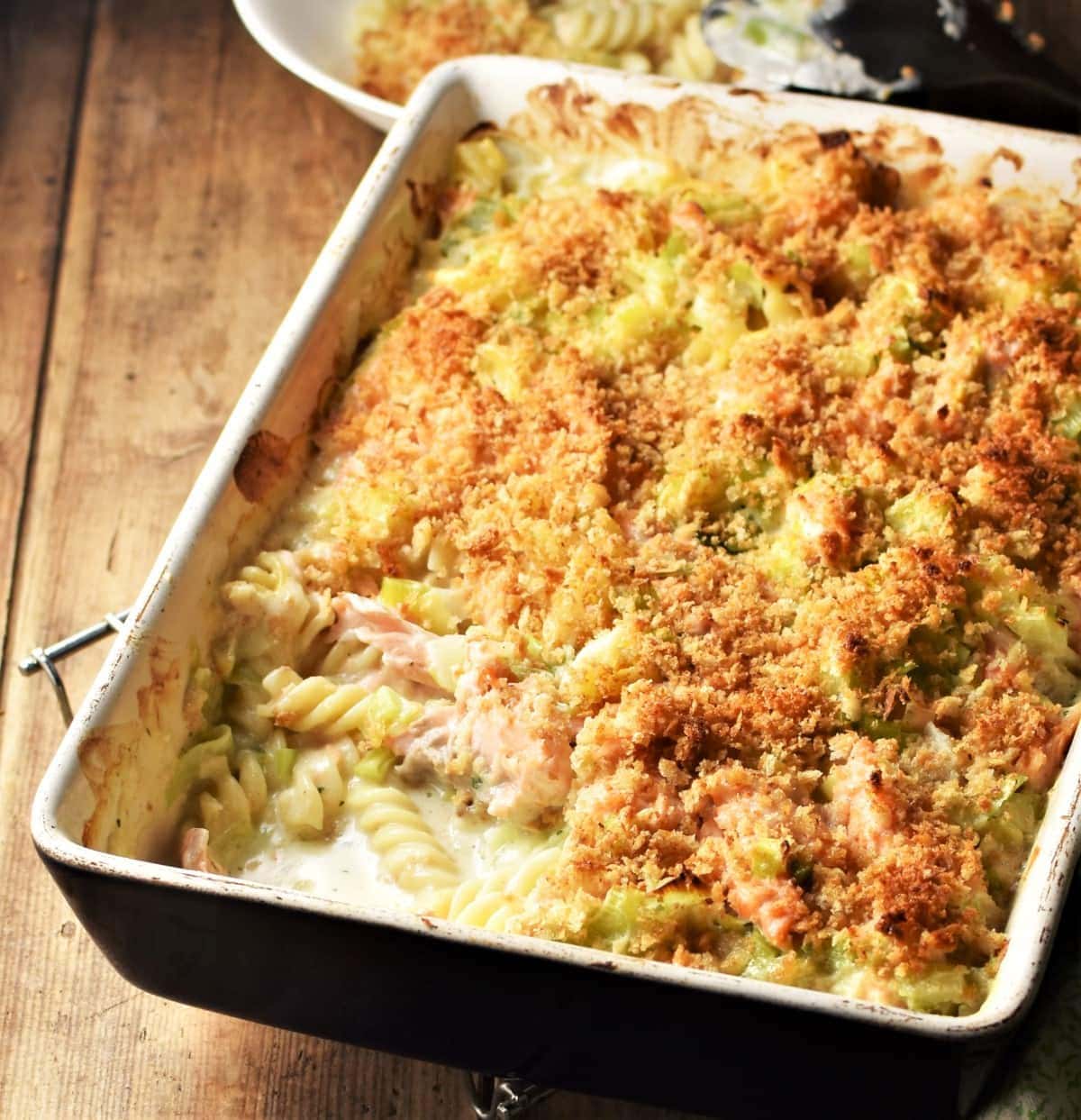 Side angle view of salmon pasta bake in rectangular dish.