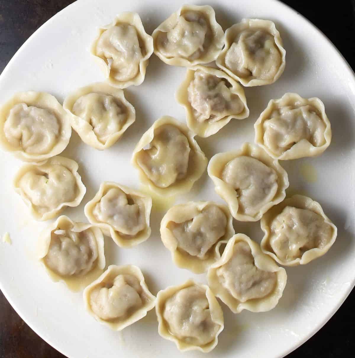 Cooked koldunai on top of white plate.